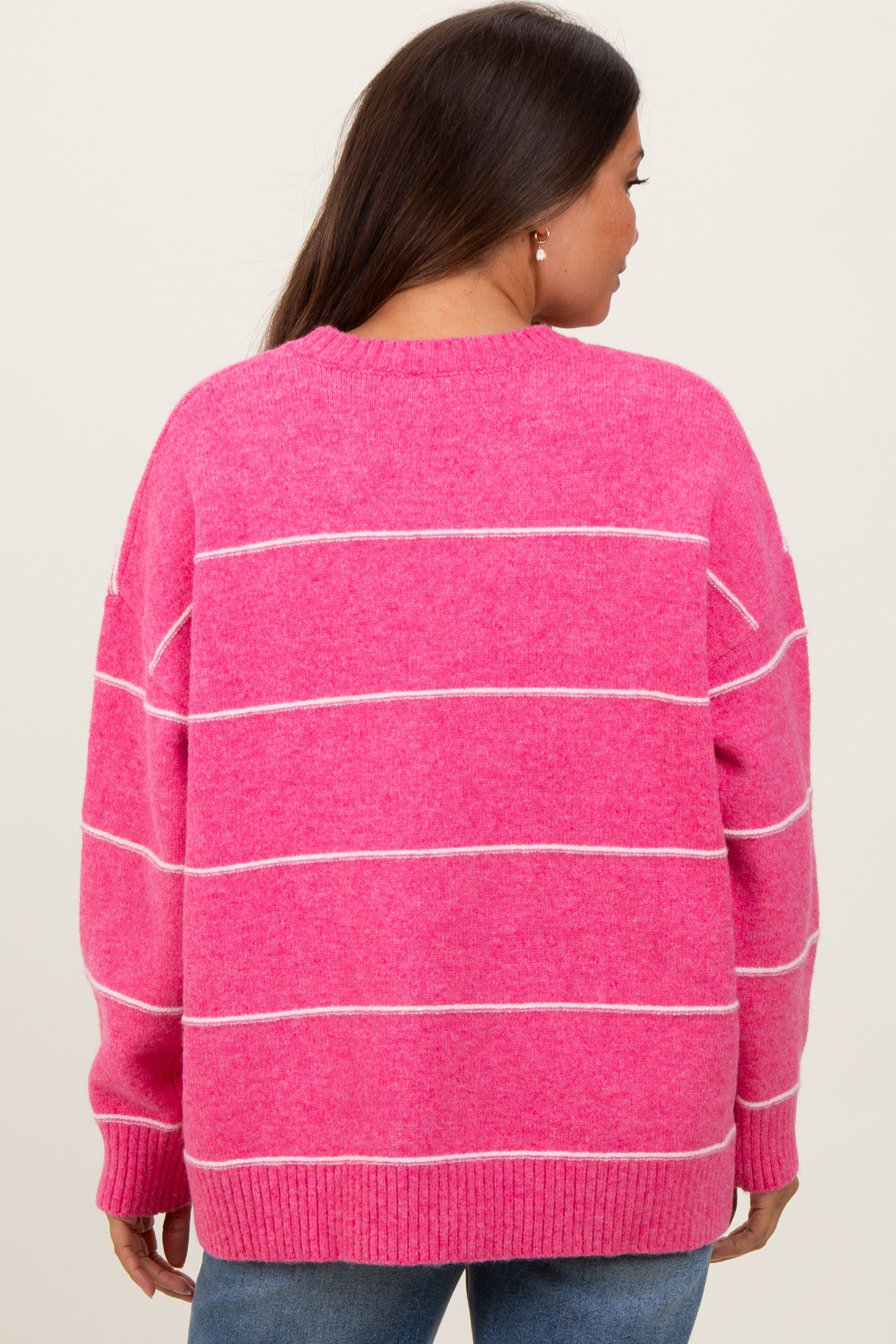 woman wearing a pink striped maternity sweater with a relaxed fit and a round neckline