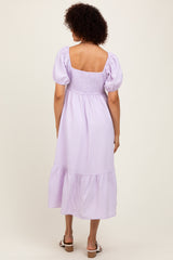 woman wearing a lavender striped midi dress with puff sleeves and a gathered back detail