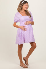 woman wearing a lavender maternity dress with puff sleeves, square neckline, and holding her baby bump