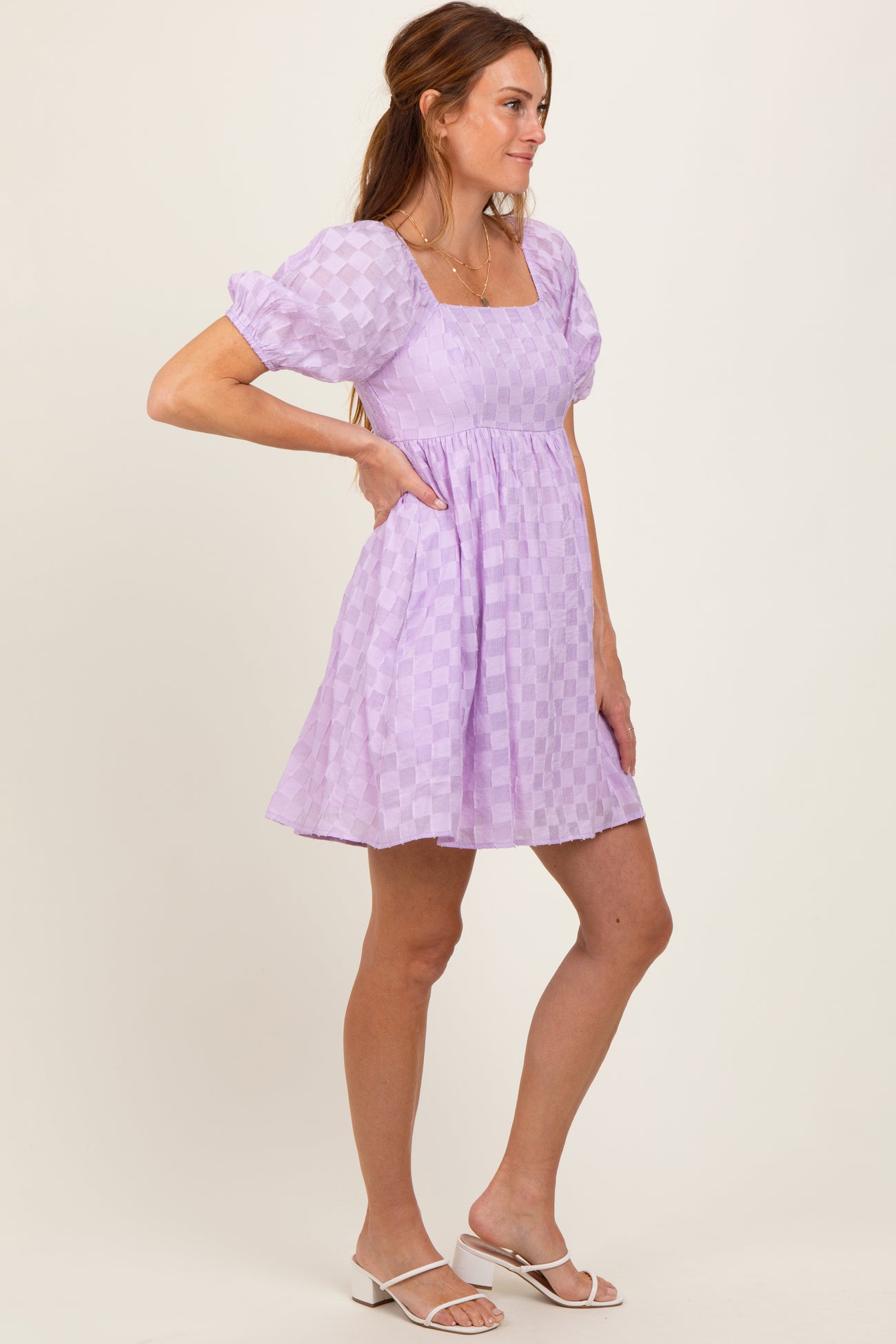 woman wearing a lavender checkered mini dress with puff sleeves and a square neckline