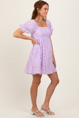 woman wearing a lavender checkered mini dress with puff sleeves and a square neckline
