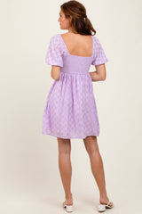 woman wearing a lilac checkered short sleeve dress with a square back and fitted bodice