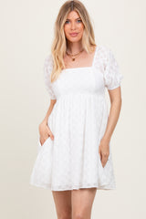 woman wearing a white short puff sleeve dress with a square neckline and pockets