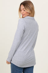 woman wearing a gray long sleeve collared top, viewed from the back, with a relaxed fit and subtle texture