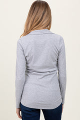 woman wearing a grey long sleeve maternity top, shown from the back, with a fitted style