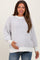 woman wearing a light purple striped maternity sweater and holding her baby bump