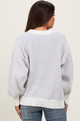 woman wearing a light gray and white striped maternity sweater with balloon sleeves, viewed from the back