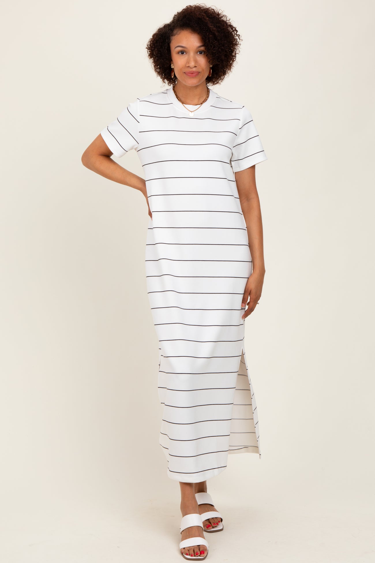 woman wearing a white striped maxi dress with short sleeves and side slits