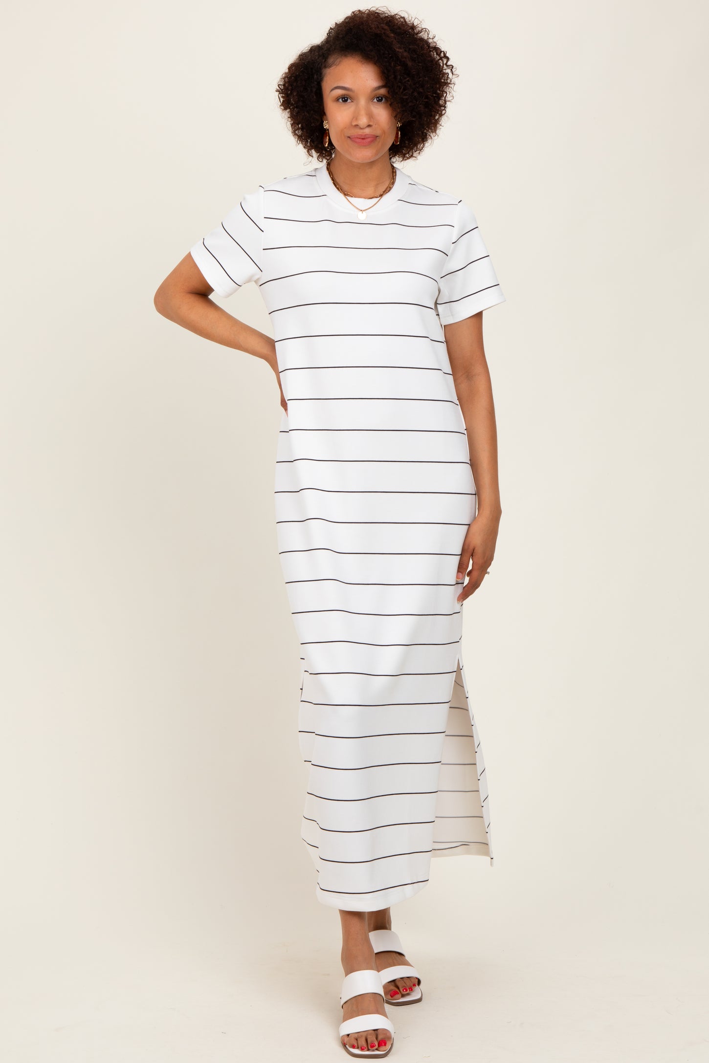 woman wearing a white striped maxi dress with short sleeves and side slits