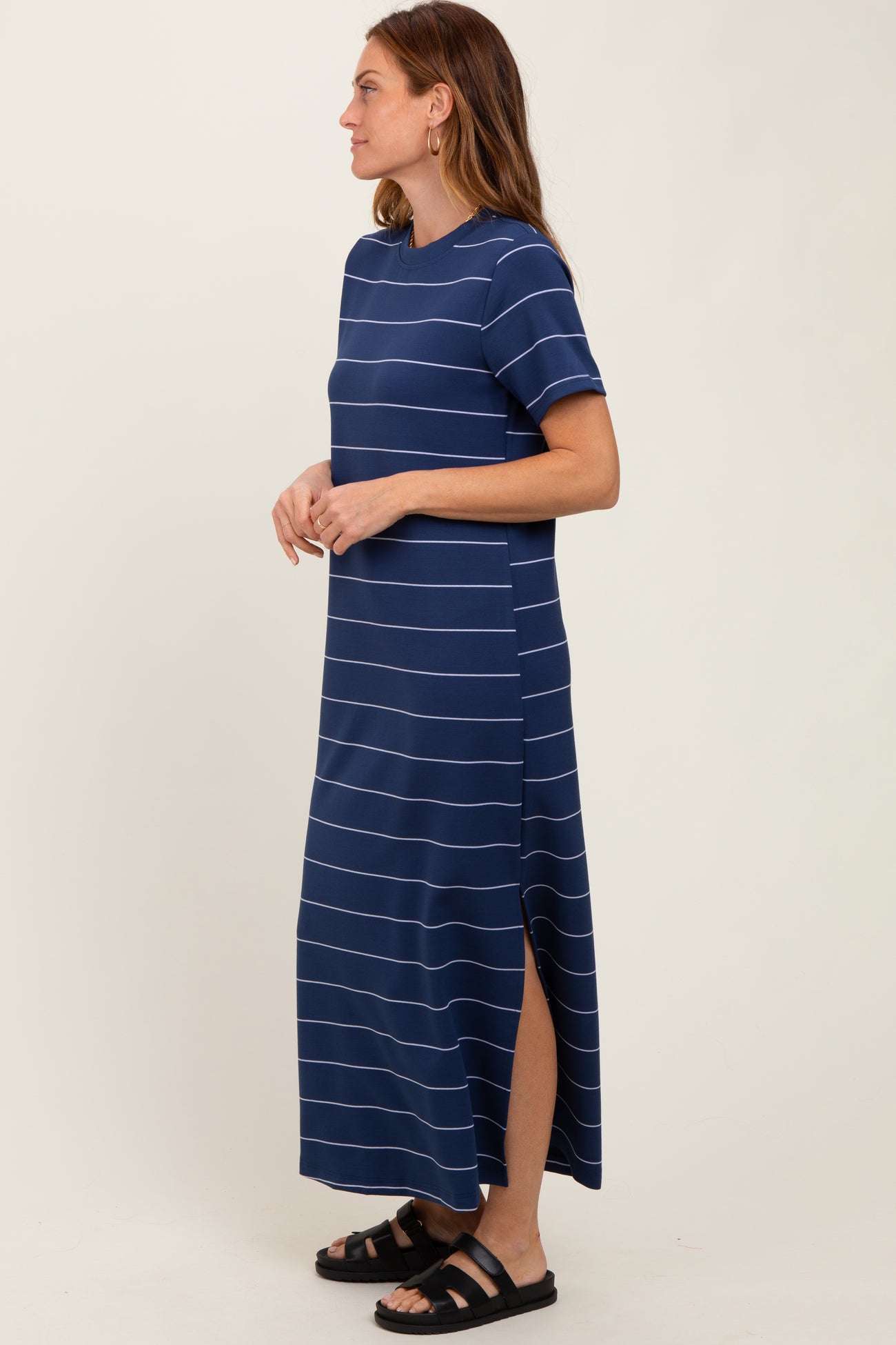 woman wearing a navy blue striped maxi dress with short sleeves and side slits
