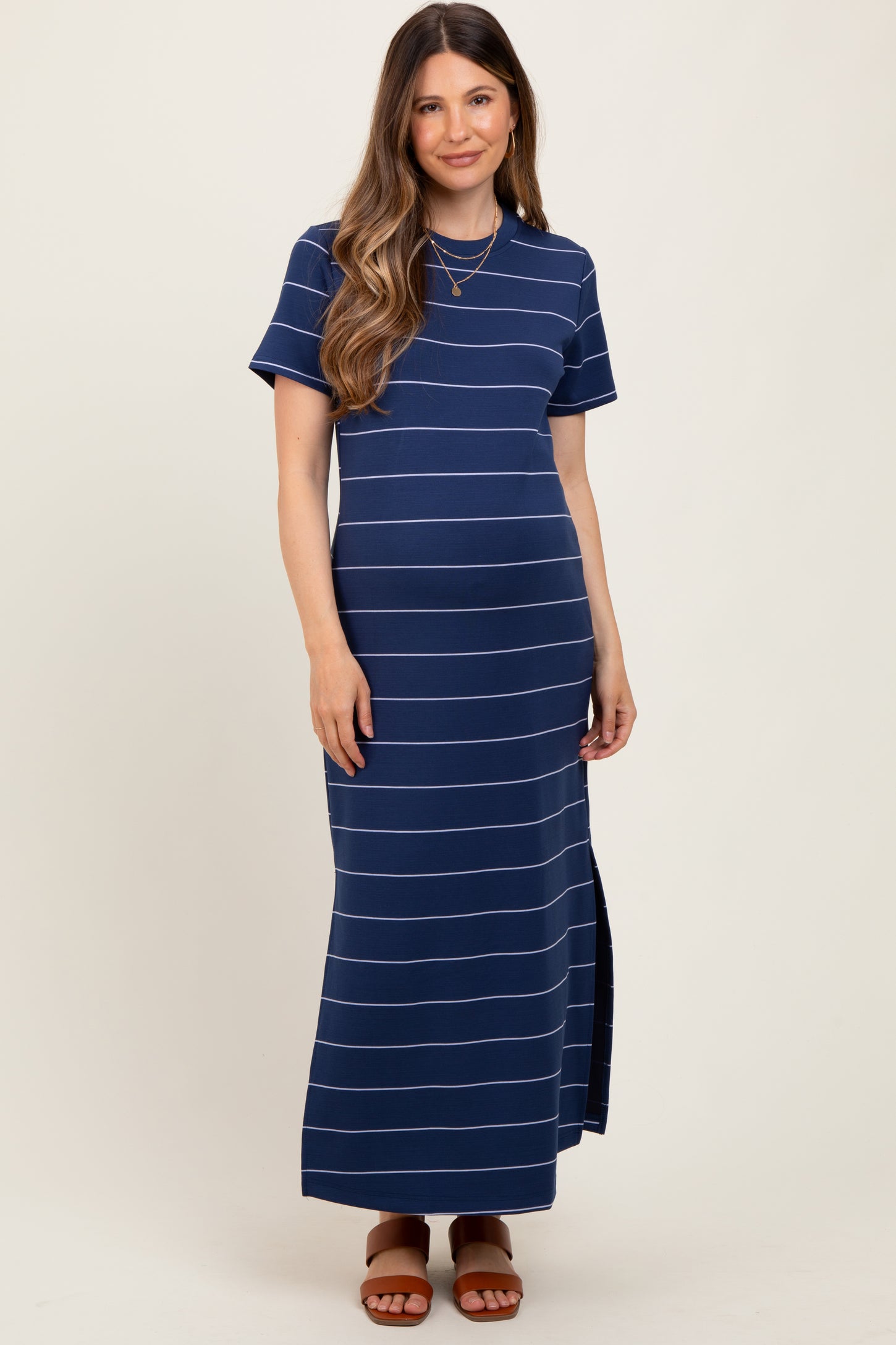 woman wearing a navy blue striped maternity maxi dress with short sleeves and side slit