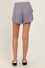 woman wearing gray athletic shorts with a stretchy waistband and side pockets, seen from the back