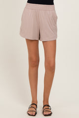woman wearing beige elastic waist shorts with side pockets and black strappy sandals