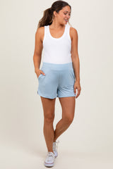 woman wearing a white tank top and light blue maternity shorts with pockets