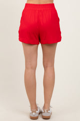 woman wearing red athletic shorts, shown from the back, with an elastic waistband and side pockets