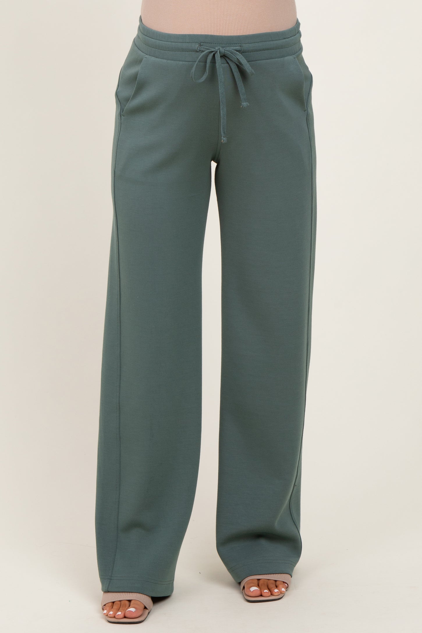 woman wearing green maternity sweatpants with a drawstring waistband and wide legs