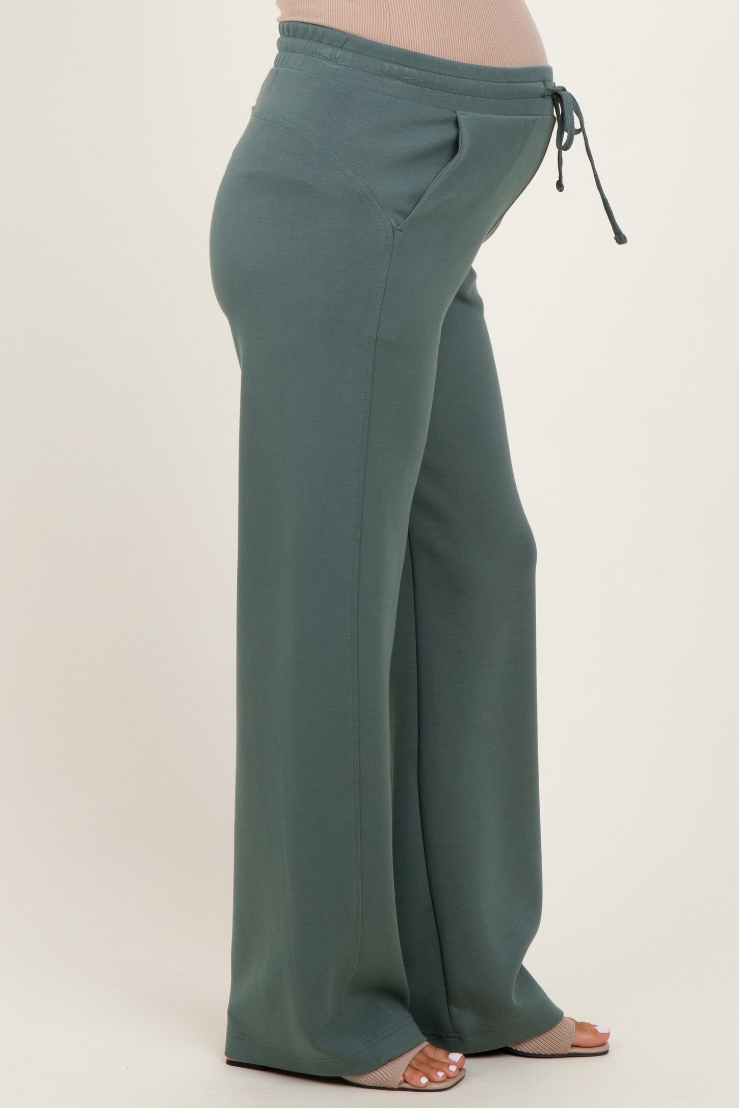 woman wearing green maternity sweatpants with a drawstring waist and visible baby bump