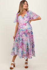 woman wearing a floral print maternity dress with short flutter sleeves and a v-neckline