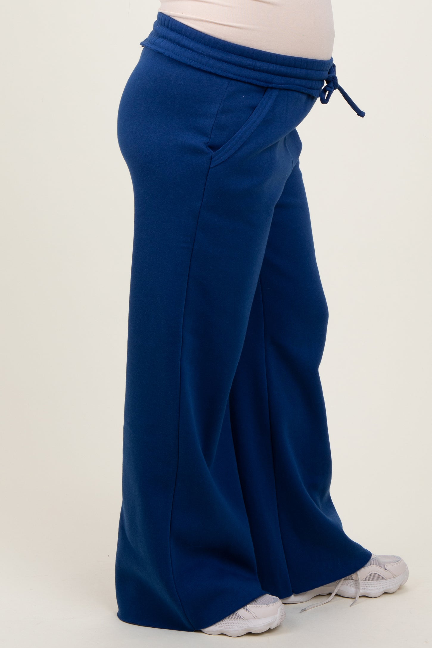 maternity wear in blue wide-leg sweatpants with a drawstring waist and side pockets, featuring a visible baby bump