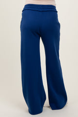 woman wearing navy blue maternity wide-leg pants with a comfortable waistband and side pockets, showcasing a relaxed fit