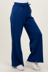 woman wearing high-waisted navy blue wide-leg pants with pockets and a drawstring waistband