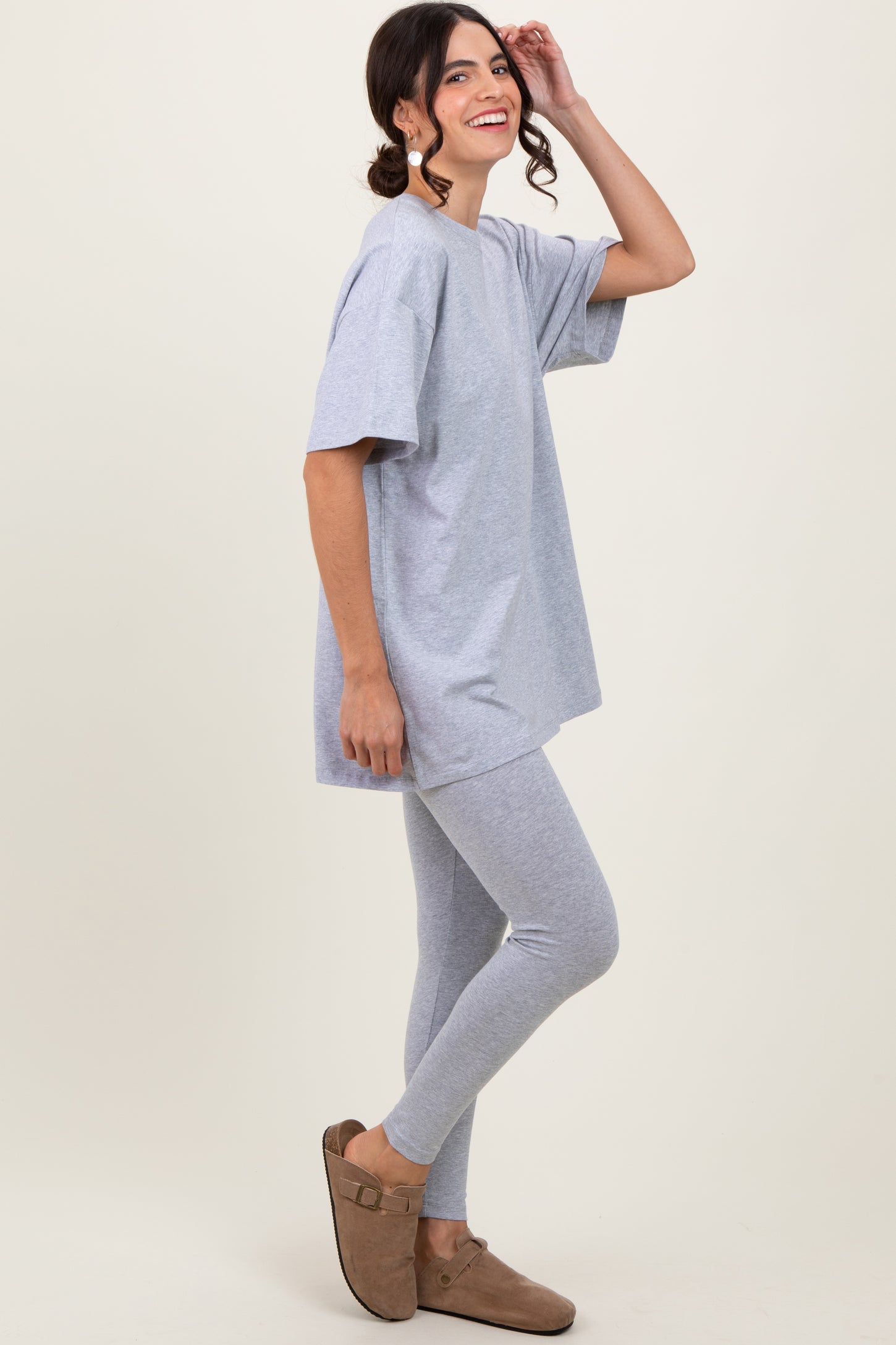 woman wearing a gray oversized t-shirt and matching gray leggings with brown slip-on shoes