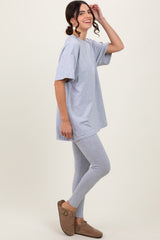 woman wearing a gray oversized t-shirt and matching gray leggings with brown slip-on shoes