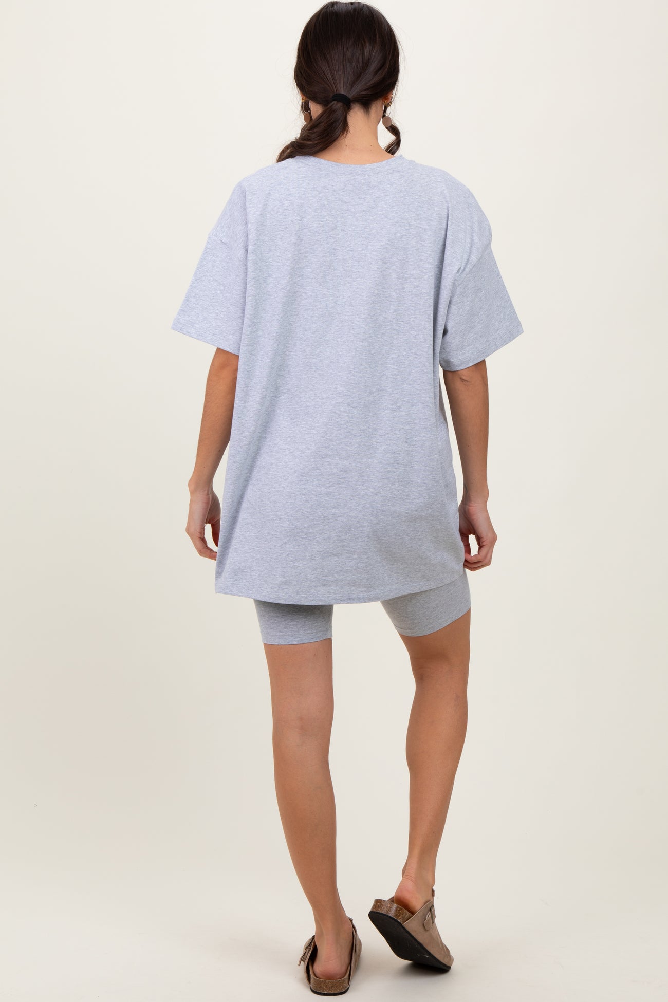 woman wearing a gray oversized t-shirt and coordinating gray biker shorts, viewed from the back