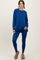 woman wearing a deep blue long sleeve top and matching leggings, paired with cozy slippers