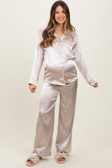 woman wearing a light beige satin maternity pajama set with long sleeves and pants, showcasing her baby bump