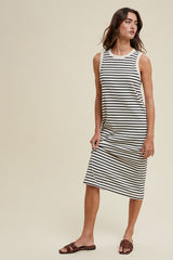 woman wearing a black and white striped sleeveless midi dress with a relaxed fit