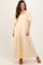 woman wearing a yellow puff sleeve maxi dress with floral details and a tiered skirt, standing against a neutral background