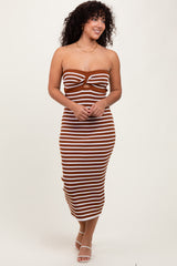woman wearing a brown and white striped strapless midi dress with a knotted detail, smiling and walking