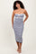 woman wearing a strapless navy and white striped midi dress with a front twist detail and a fitted silhouette