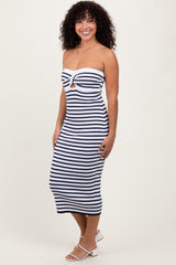 woman wearing a strapless navy and white striped midi dress with a front keyhole detail and a fitted silhouette