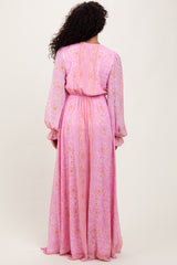 woman wearing a pink floral maxi dress with long sleeves and a cinched waist, viewed from the back