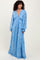 woman wearing a long sleeve blue bohemian maxi dress with a deep v-neck and intricate patterns