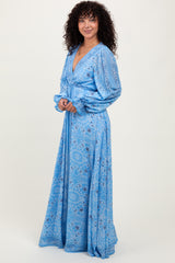 woman wearing a blue paisley print maxi dress with long sleeves and a deep V-neckline
