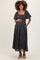 woman wearing a black floral maternity maxi dress with puff sleeves and a gathered waist, holding her baby bump