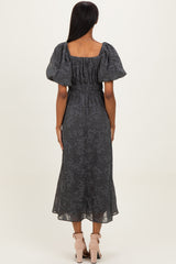 woman wearing a gray floral lace maxi dress with puff sleeves and a fitted waist, viewed from the back