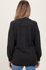 woman wearing a dark gray oversized maternity sweater, showing the back view with dropped shoulders and relaxed fit