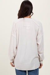 woman wearing a light beige oversized sweater with a relaxed fit and dropped shoulder seams