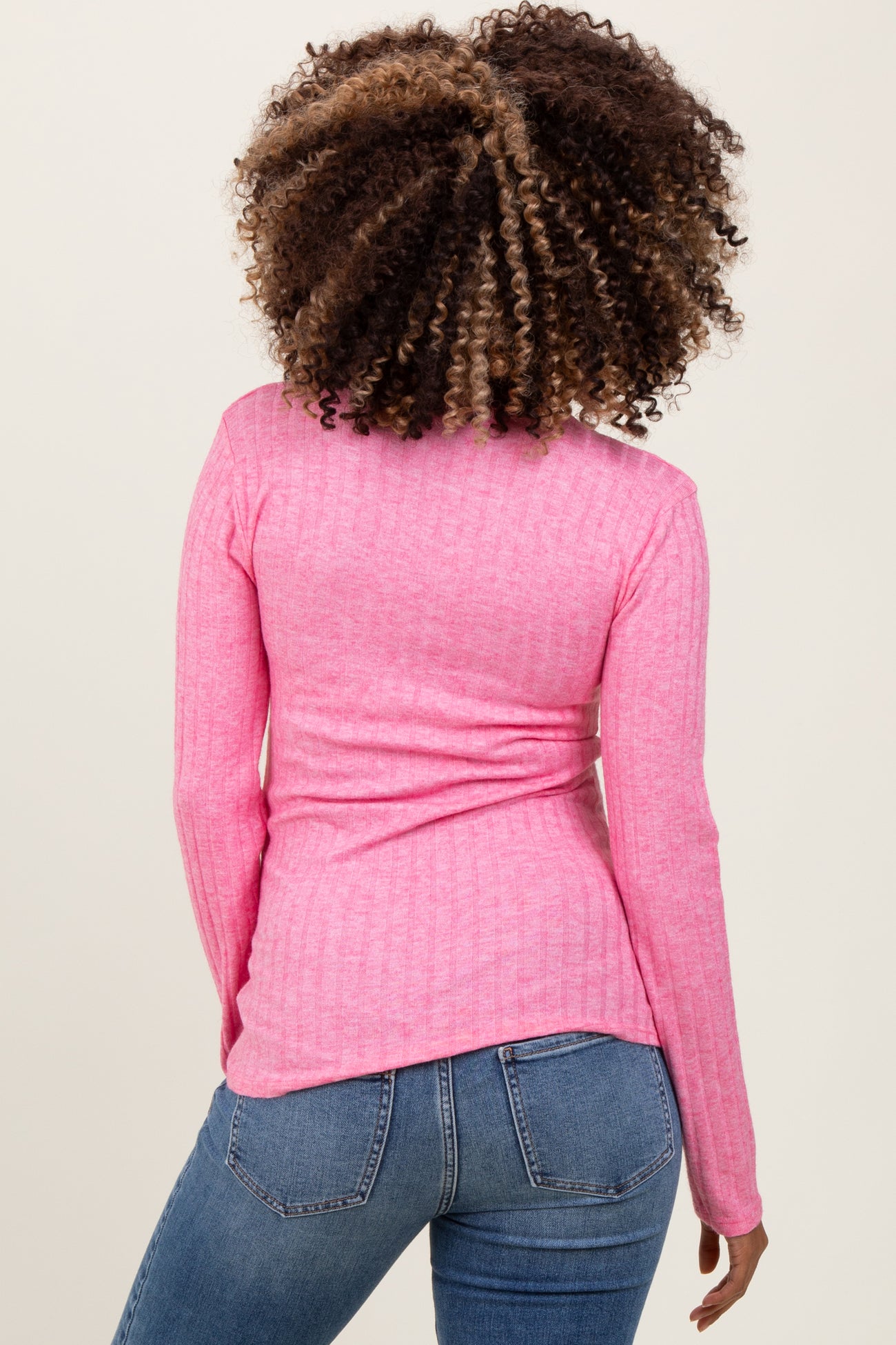 woman wearing a pink long sleeve maternity top with a fitted style and ribbed texture, viewed from the back