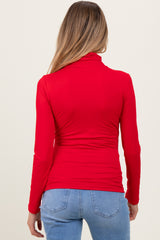 woman wearing a red long sleeve maternity top, viewed from the back, with fitted design and gathered details at the waist