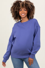 woman wearing a purple maternity sweatshirt with a relaxed fit and visible baby bump