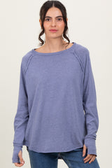 woman wearing a purple long sleeve top with a relaxed fit and raglan seams, styled with casual jeans
