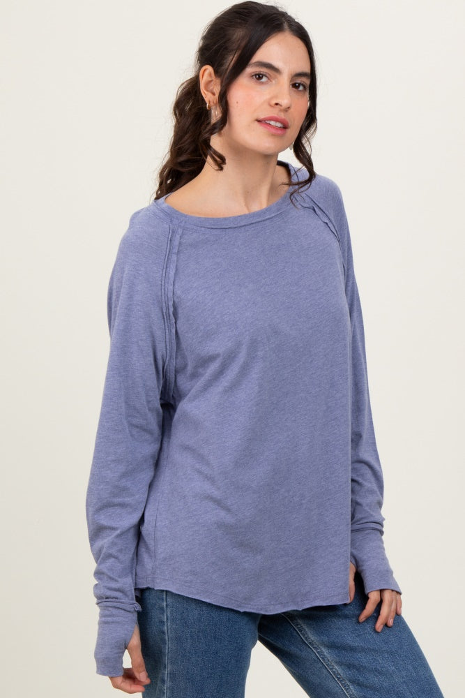 woman wearing a lavender long sleeve top with a relaxed fit and raglan sleeves, paired with blue jeans