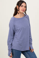woman wearing a lavender long sleeve top with a relaxed fit and raglan sleeves, paired with blue jeans