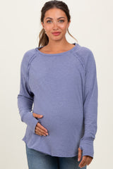 woman wearing a lavender long sleeve maternity top and holding her baby bump