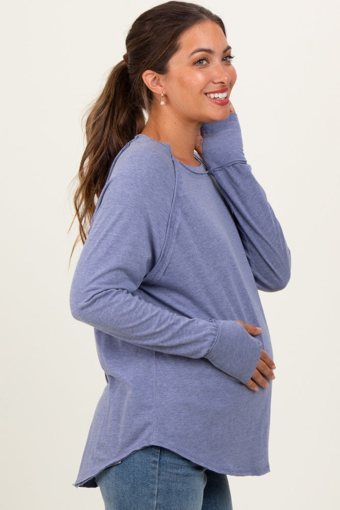 woman wearing a purple long sleeve maternity top and holding her baby bump